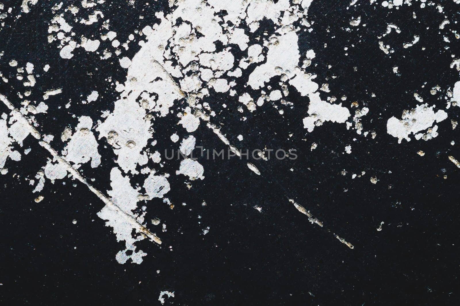 Black steel plate with white paint spots. metal surface with paint splashes. grunge texture. iron background