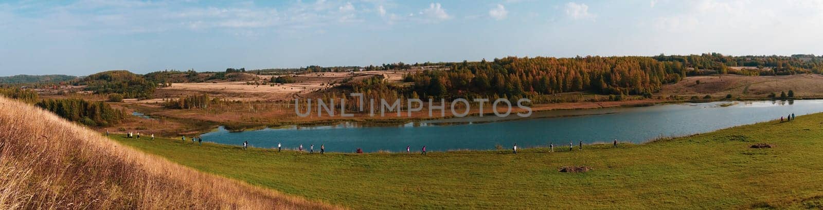 Pilgrims walk along the lake in the valley. nature landscape panorama aerial view