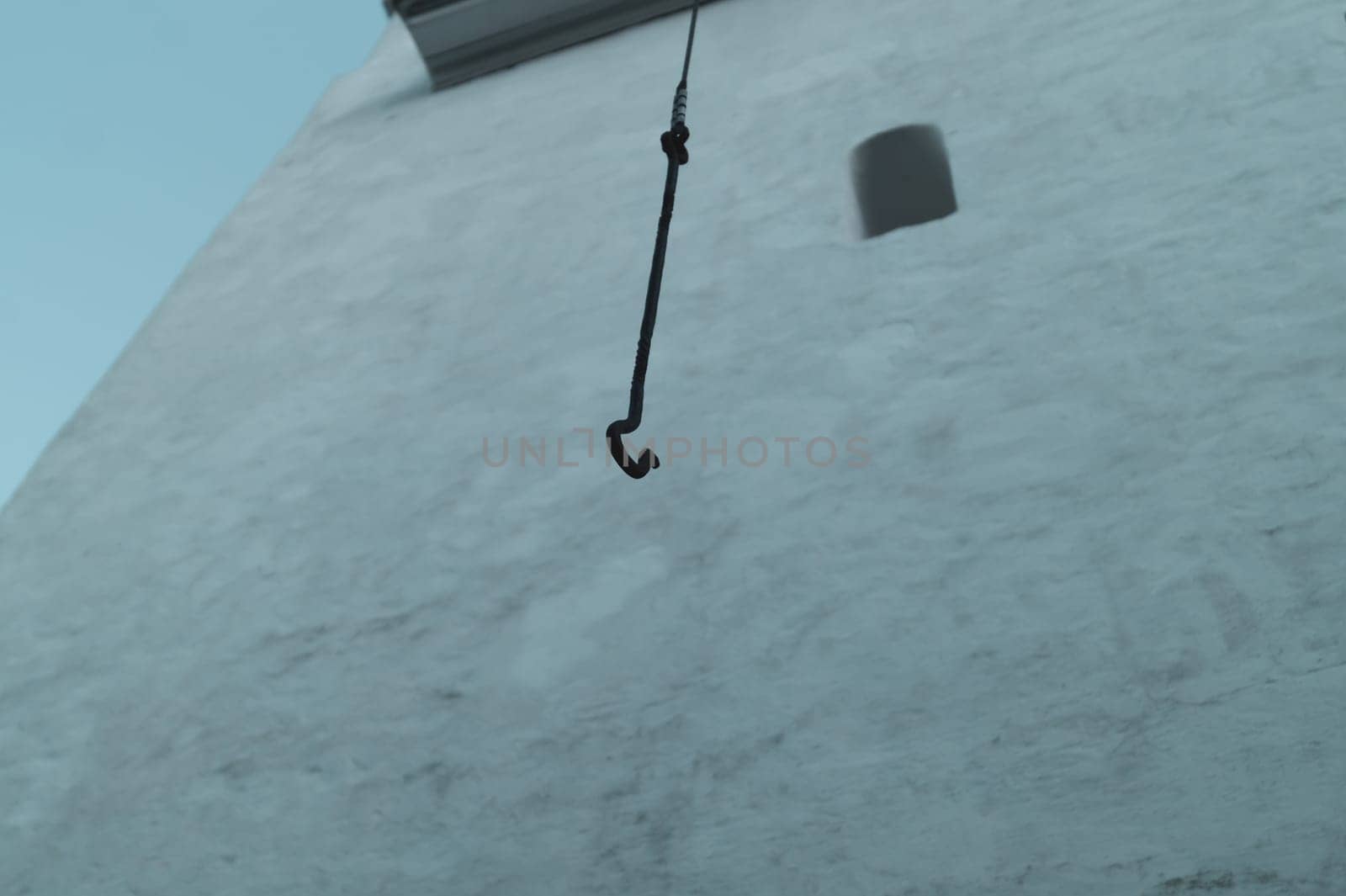 Hook of the bell is hanging down on the rope. old architecture