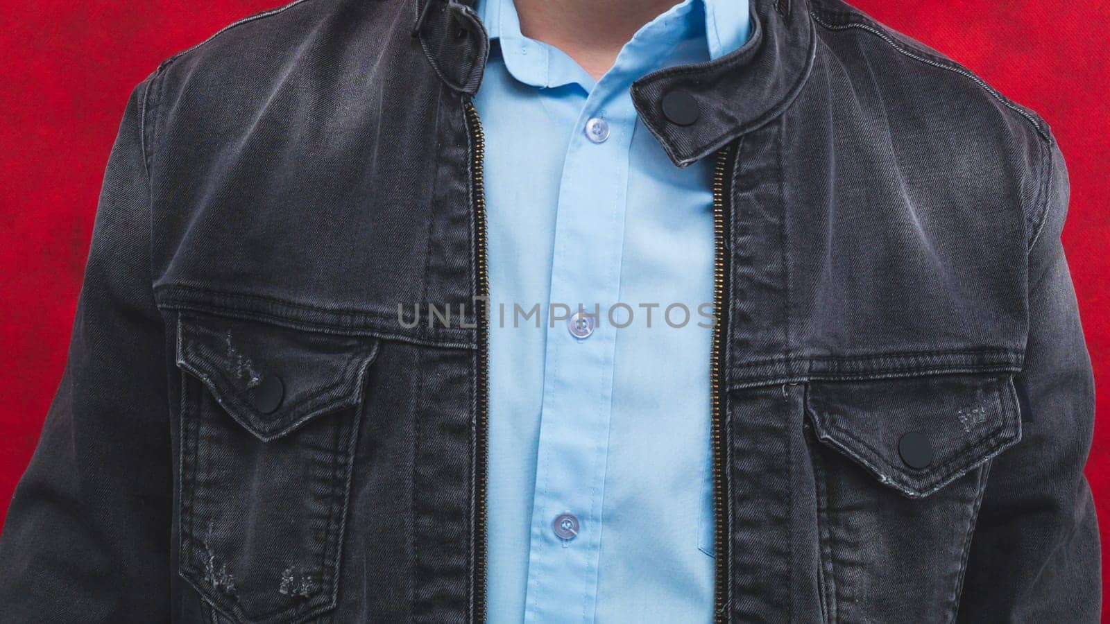 Jeans jacket and blue shirt worn by a man close up