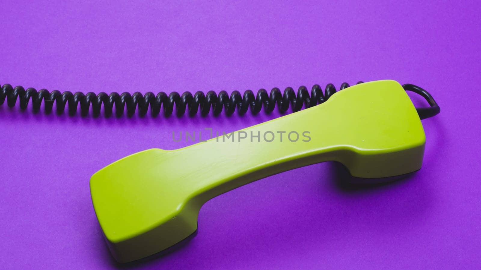 Vintage green telephone handset. phone receiver isolated on purple background. old communication technology. copy space