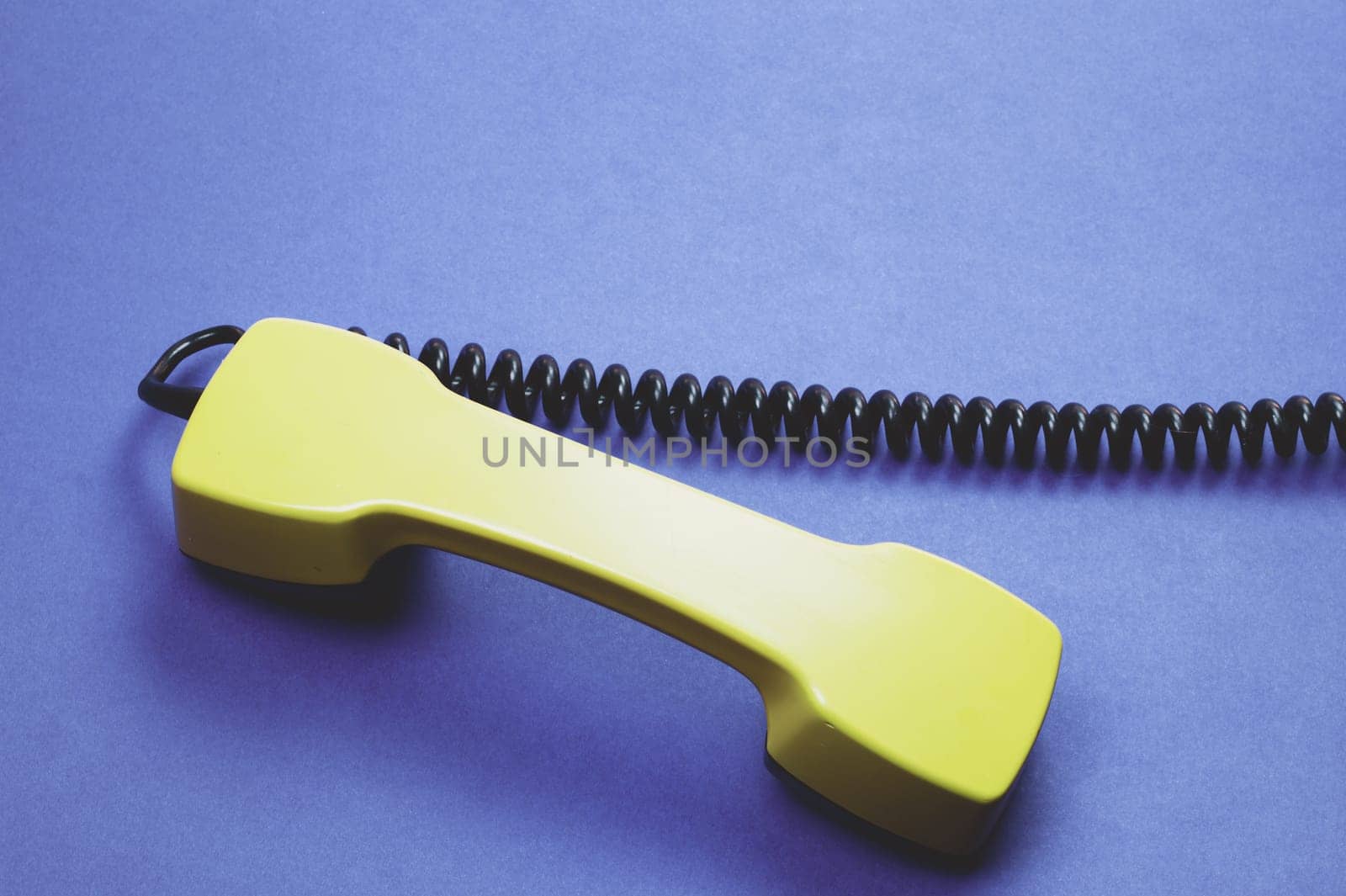 Retro telephone handset. phone receiver on blue background. old communication technology. copy space