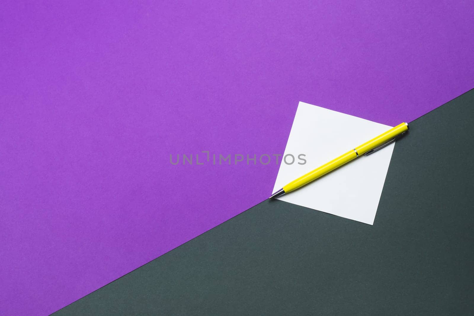Yellow pen and white note on colored background
