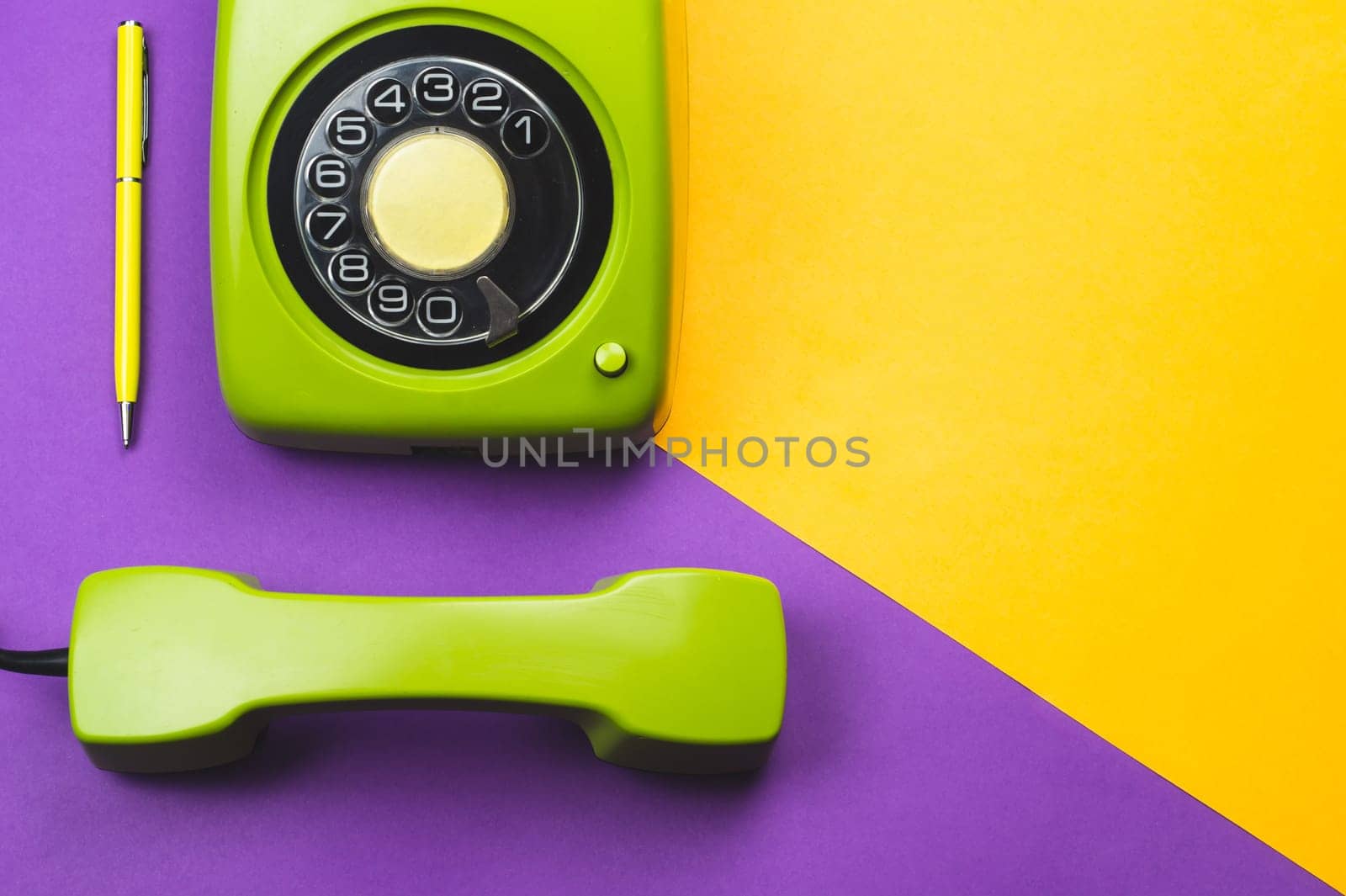 Classic green phone with yellow pen. office background. vintage telephone with phone receiver. old communication technology. copy space