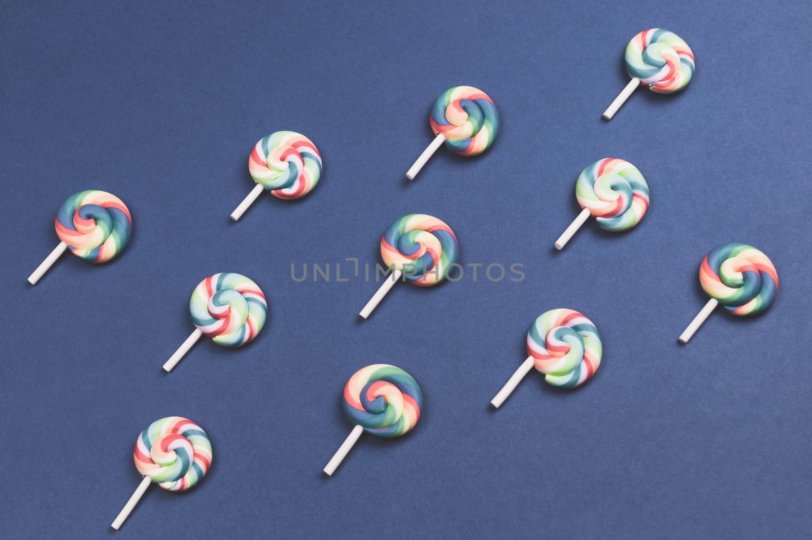 Lollipops are arranged symmetrically on a colored background. colorful candies. pattern of sweets