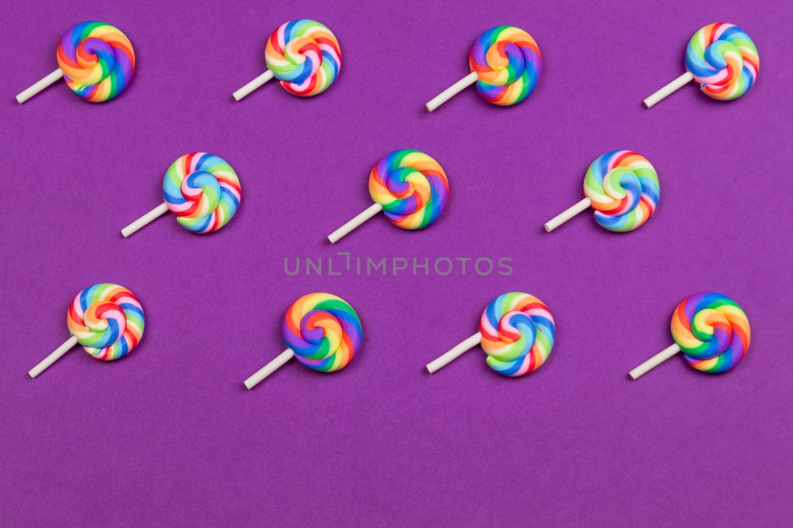 Lollipops are arranged symmetrically on a colored background. colorful candies. pattern of sweets