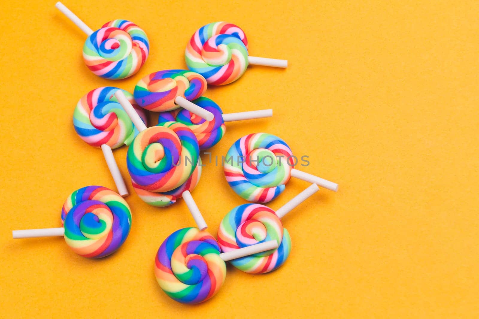 Lollipops close up. colorful candies on a yellow background. festive decoration. copy space