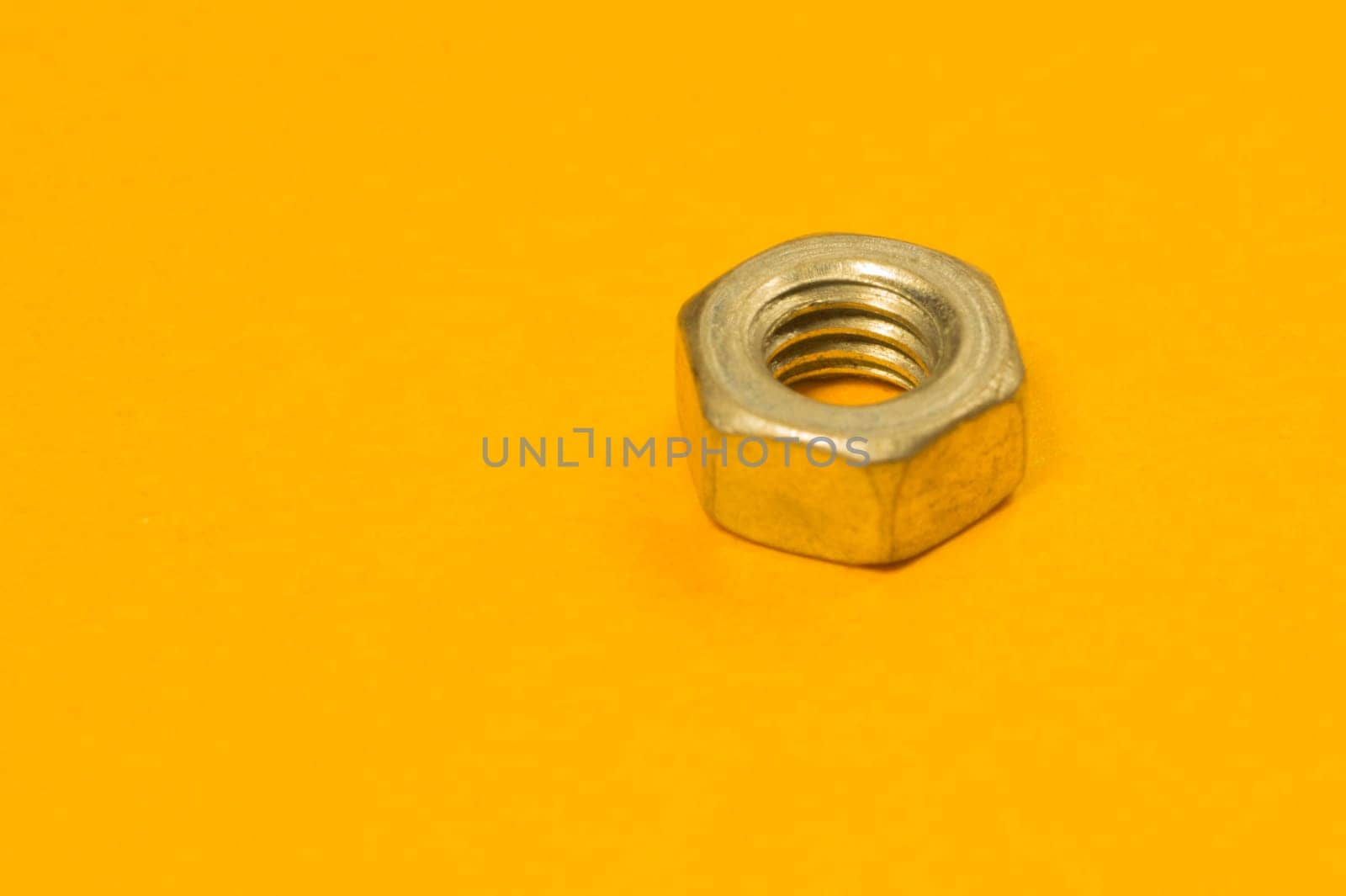 Steel screw on a yellow background. working tools
