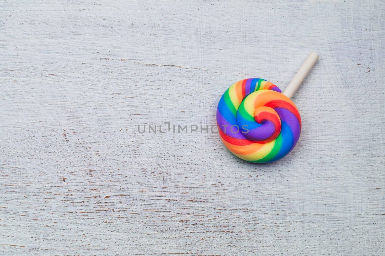 Lollipop on white wooden background. colorful candy close up. copy space