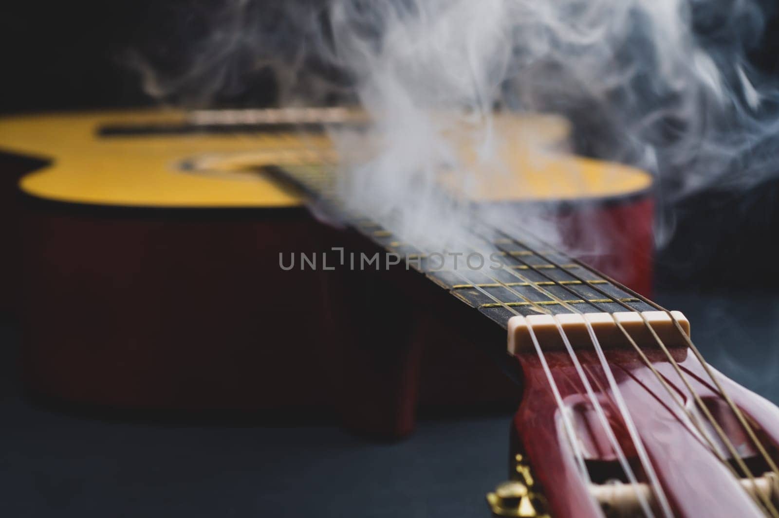 Guitar in smoke close up. acoustic musical instrument. strings on the guitar neck