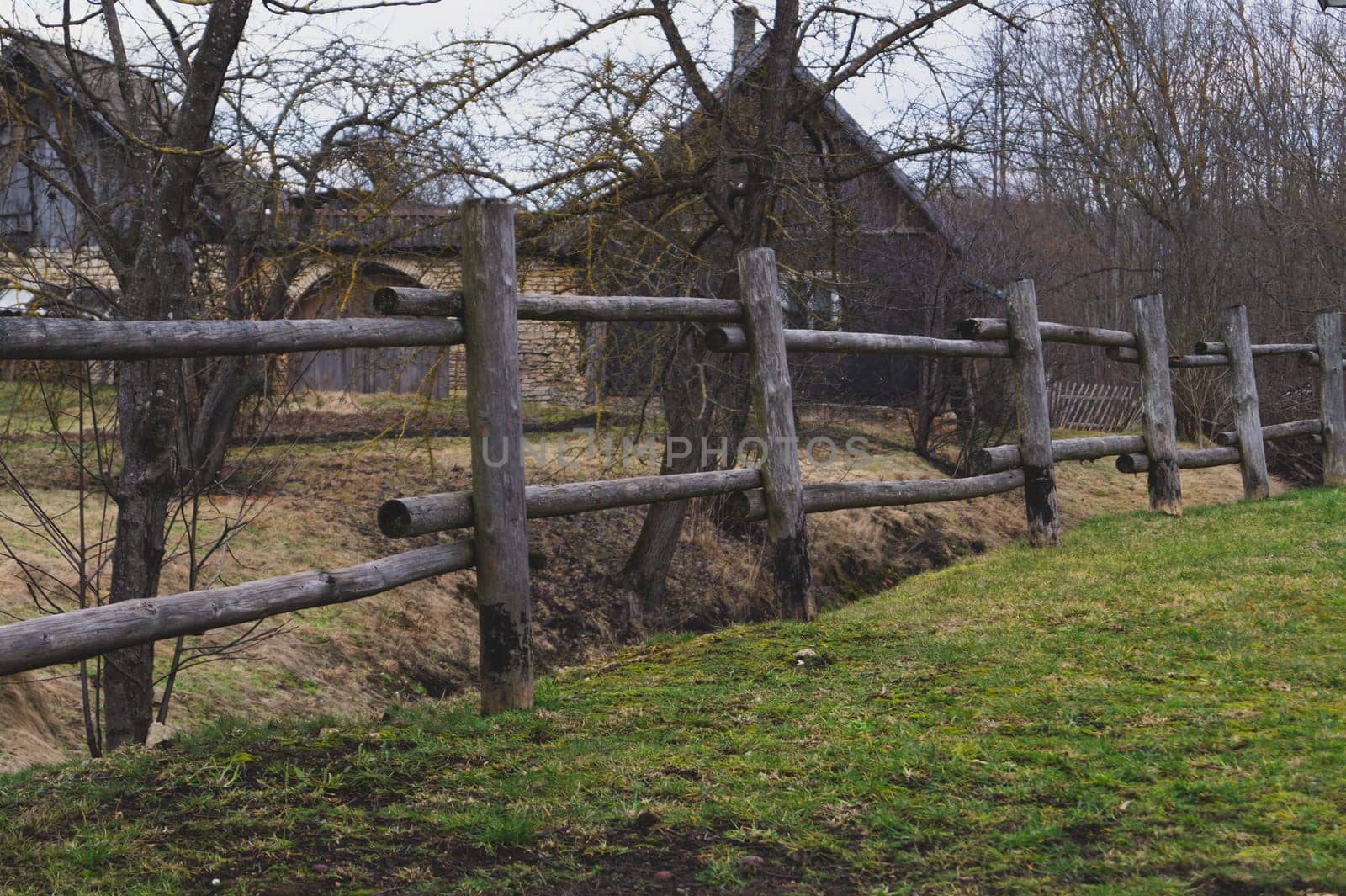 Old wooden fence with rural house behind. countryside view