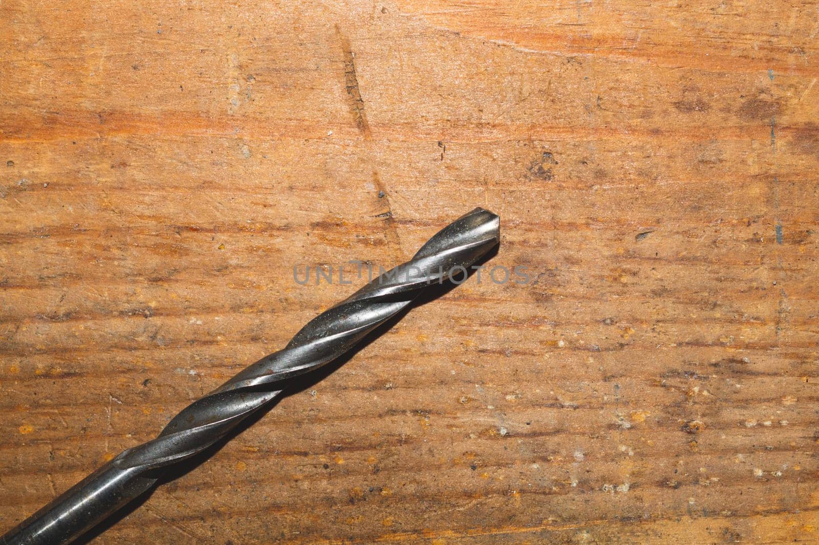 Drills on a wooden table. pile of drill bits on a wood background. work tool