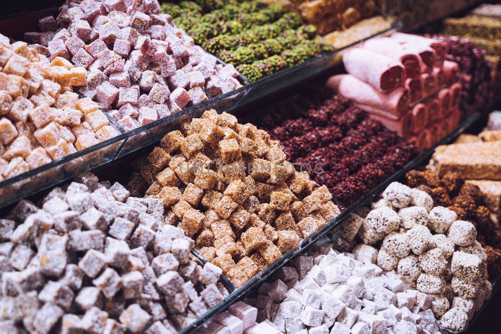 rows of Turkish delight sweets desserts with dried fruits lined up in the store window