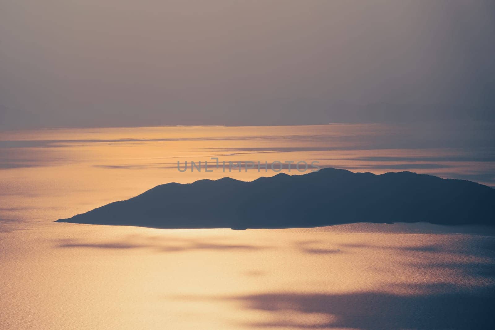 beautiful aerial panorama from the Babadag peak of high mountains rising up over the Mediterranean sea at sunset near Oludeniz Blue Lagoon coast in Turkey during summer