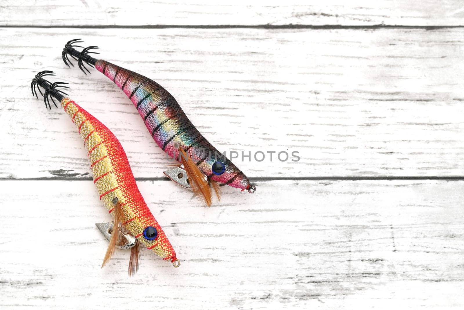 Fake bait made of shrimp shape for fishing on white wooden table