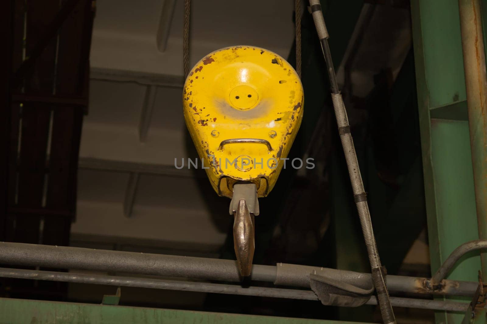 Yellow crane hook hanging in the factory. industrial background