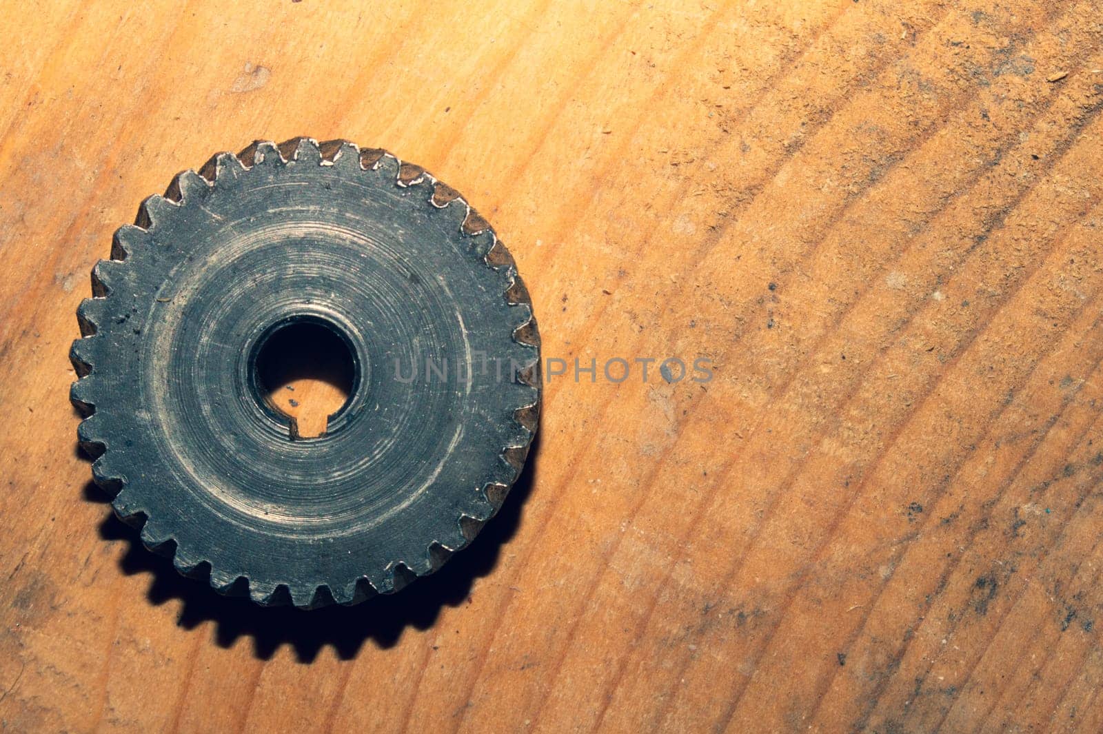 Metal gear on a wooden background. detail of mechanism