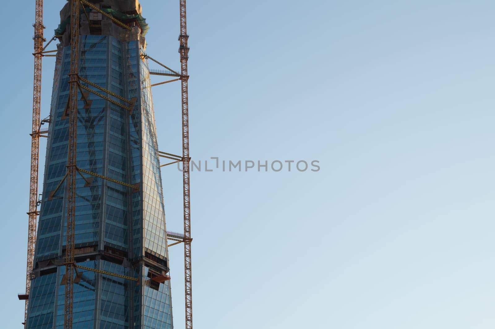 skyscraper construction. high tower with industrial crane. office glass building