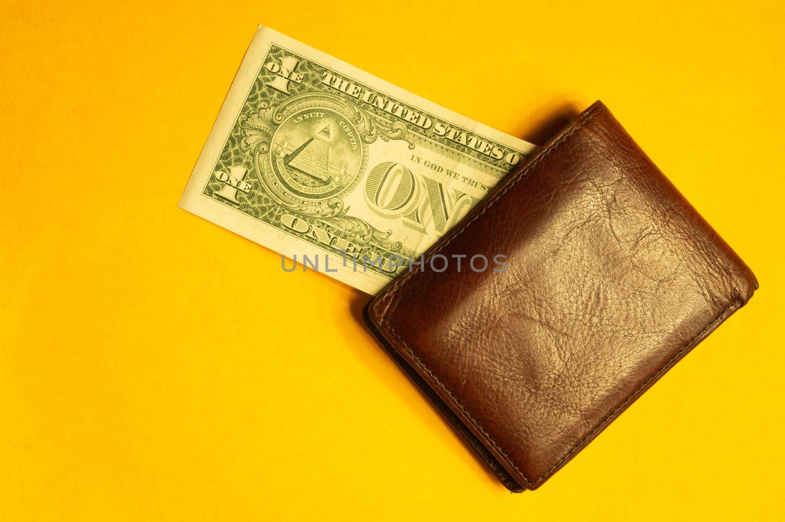 One dollar bill in wallet isolated on yellow background