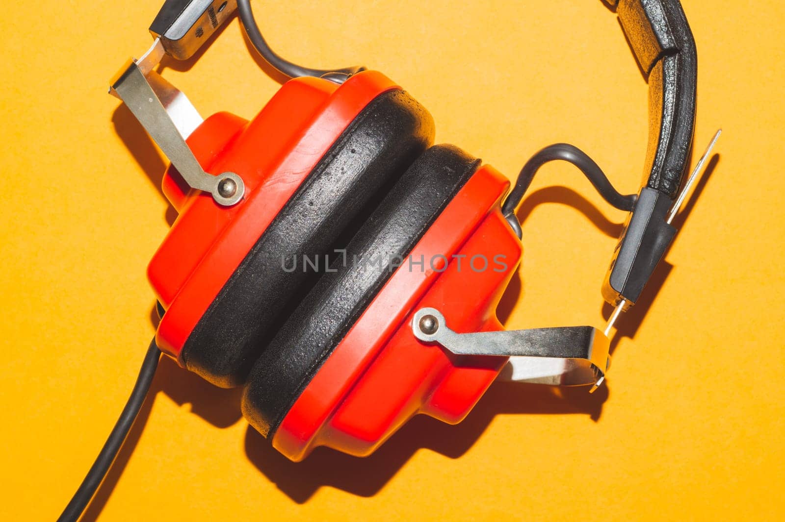 Vintage red headphones on yellow background. retro earphones