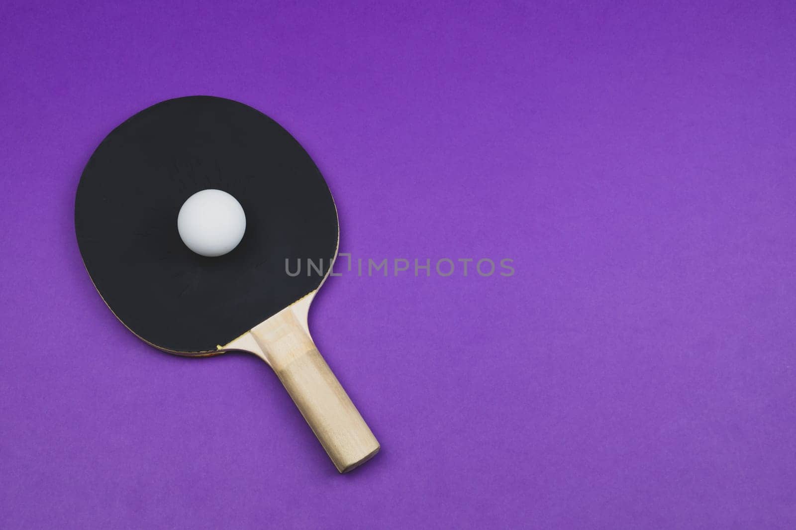 Black ping pong racket with a ball isolated on a color background. sport equipment for table tennis