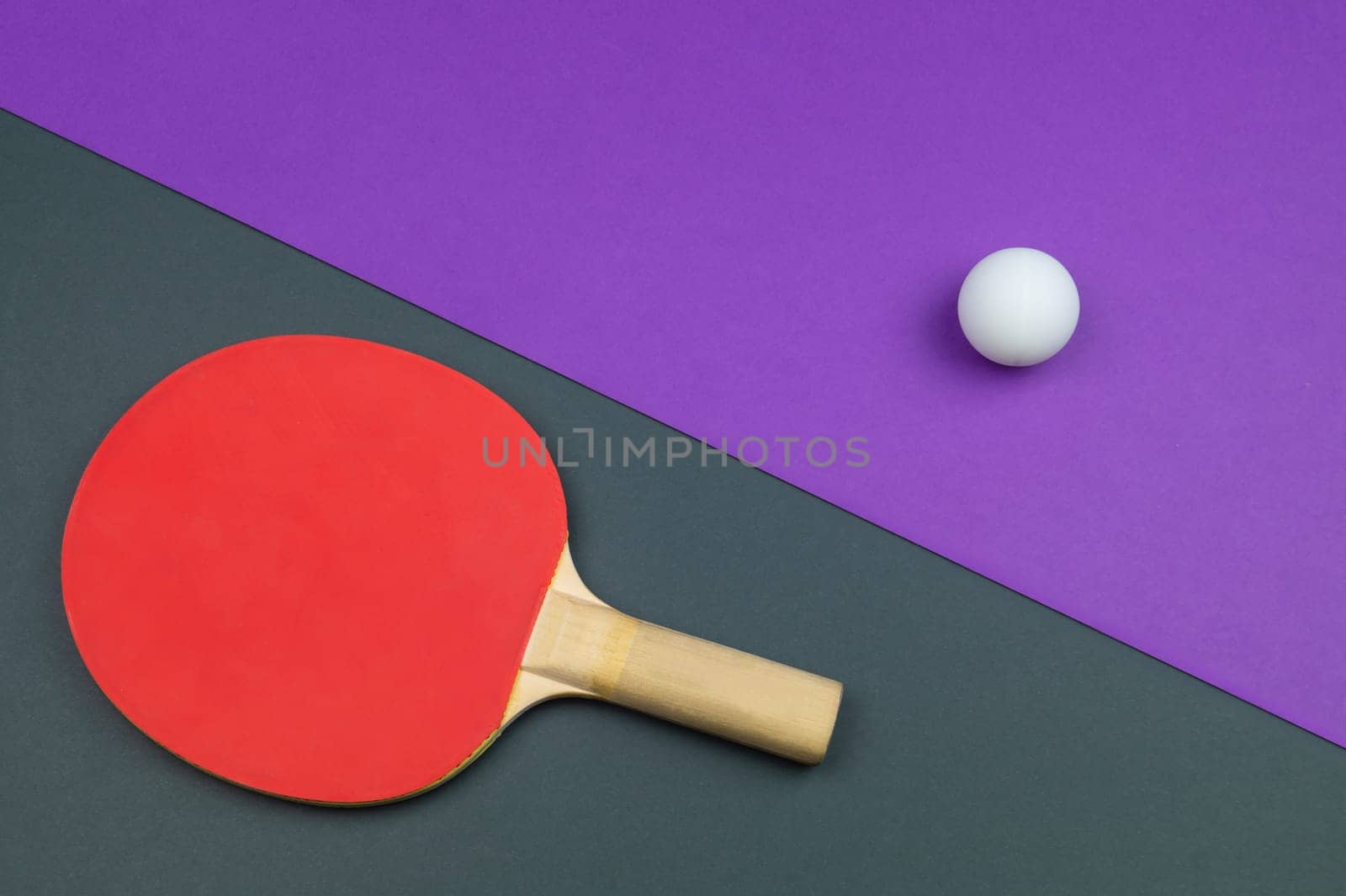 Red table tennis racket with a ball isolated on a colored background. sport equipment for ping pong. copy space