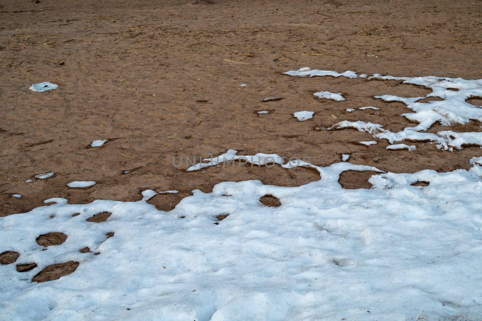 Snow covered sand. melting snow on the ground