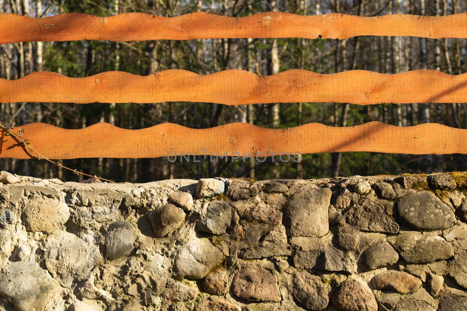 Wood and stone background. wooden fencing and natural stone wall in the park