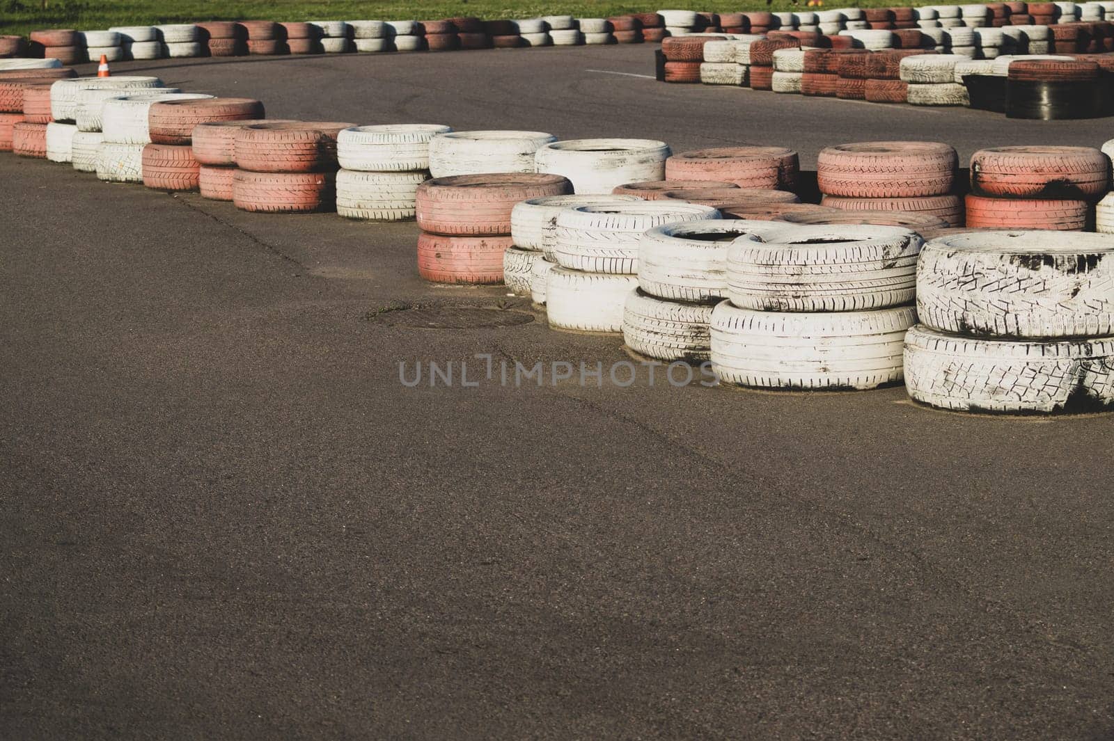 Race track safety barrier. asphalt racing track with red and white tires. colorful tires stack. karting race track