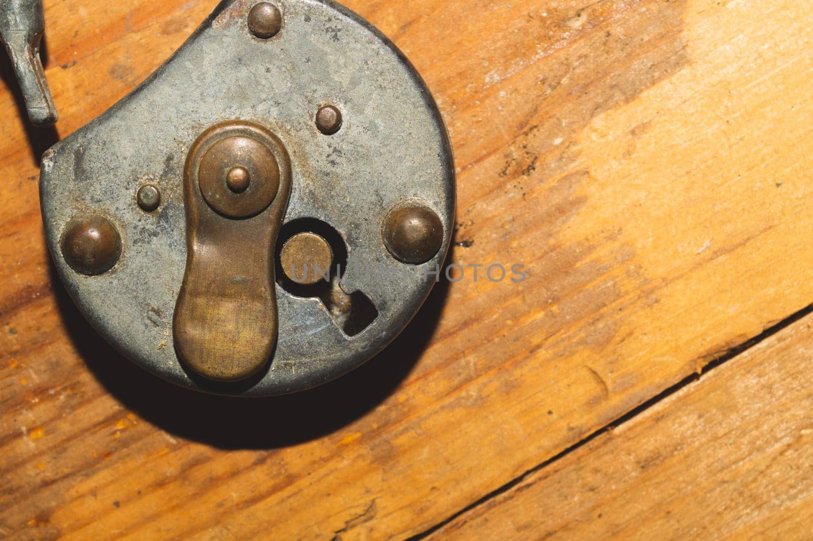 Old rusty lock on a wooden table. Vintage padlock on wood background