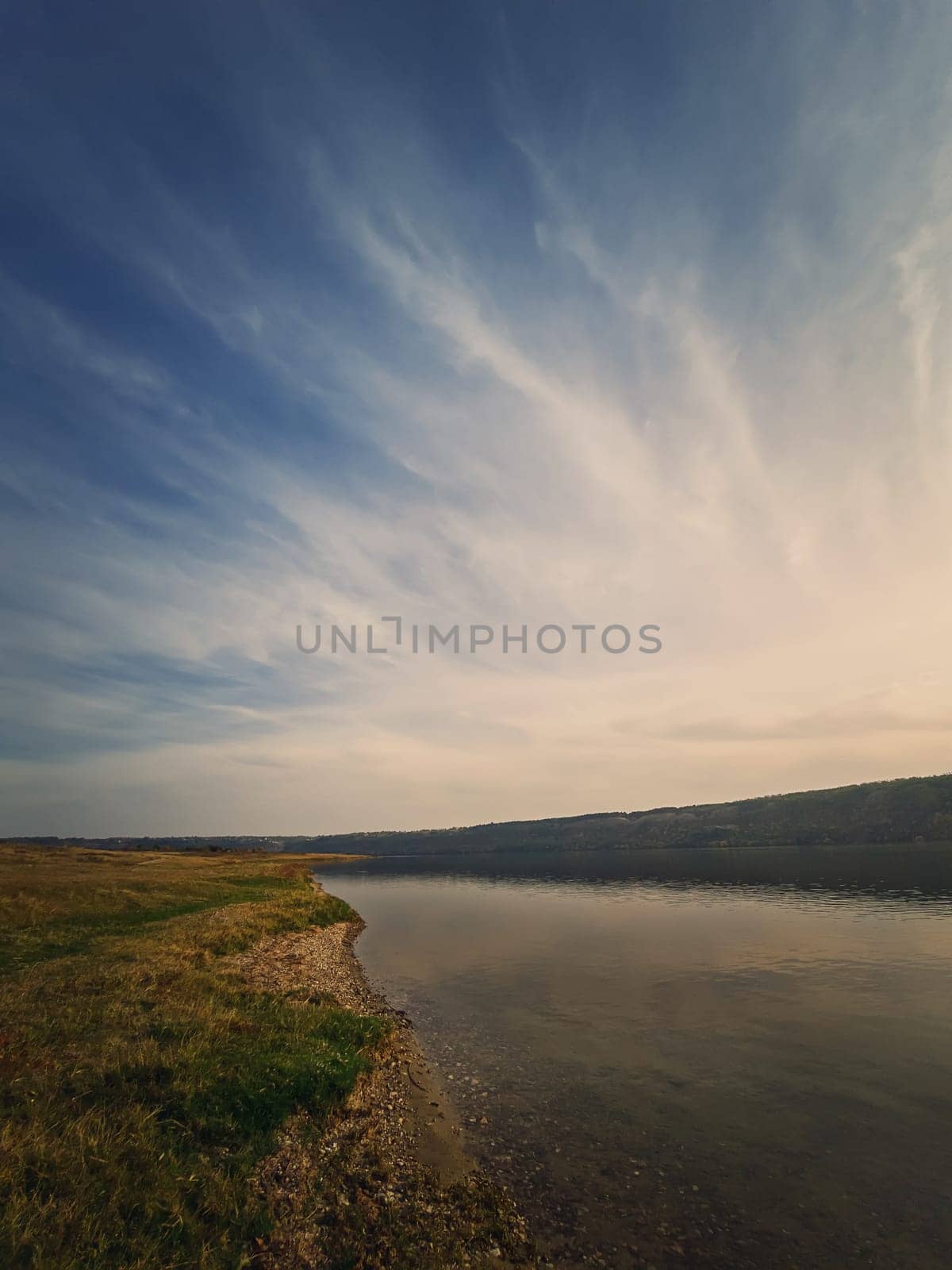 Scenic view to the riverbank of Nistru river, Moldova. Vertical background, calm water flowing. Natural landscape, silent empty place.