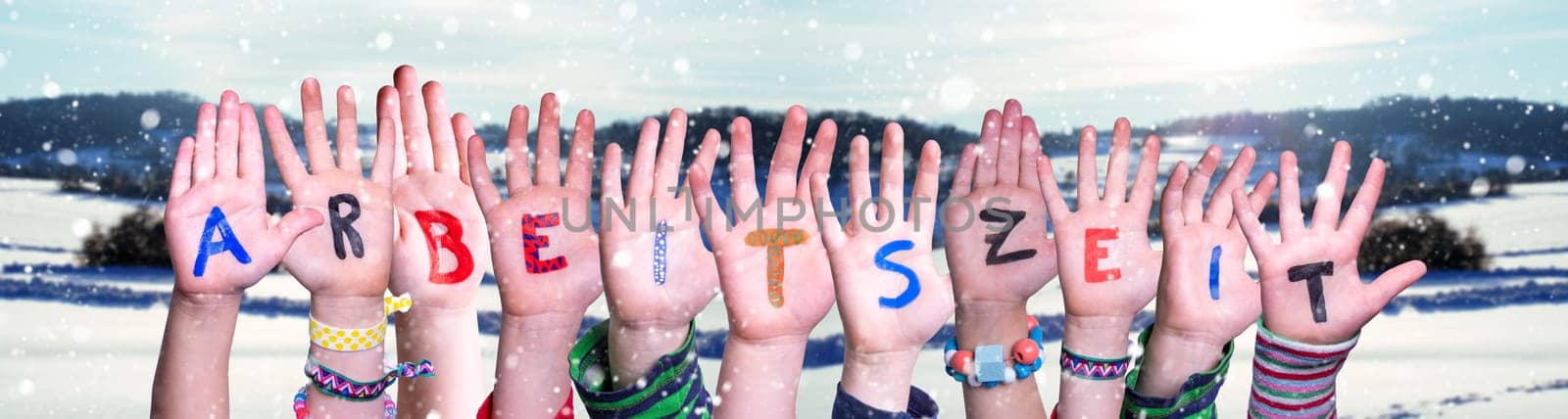 Children Hands Building Colorful German Word Arbeitszeit Means Working Hours. Snowy Winter Background With Snowflakes