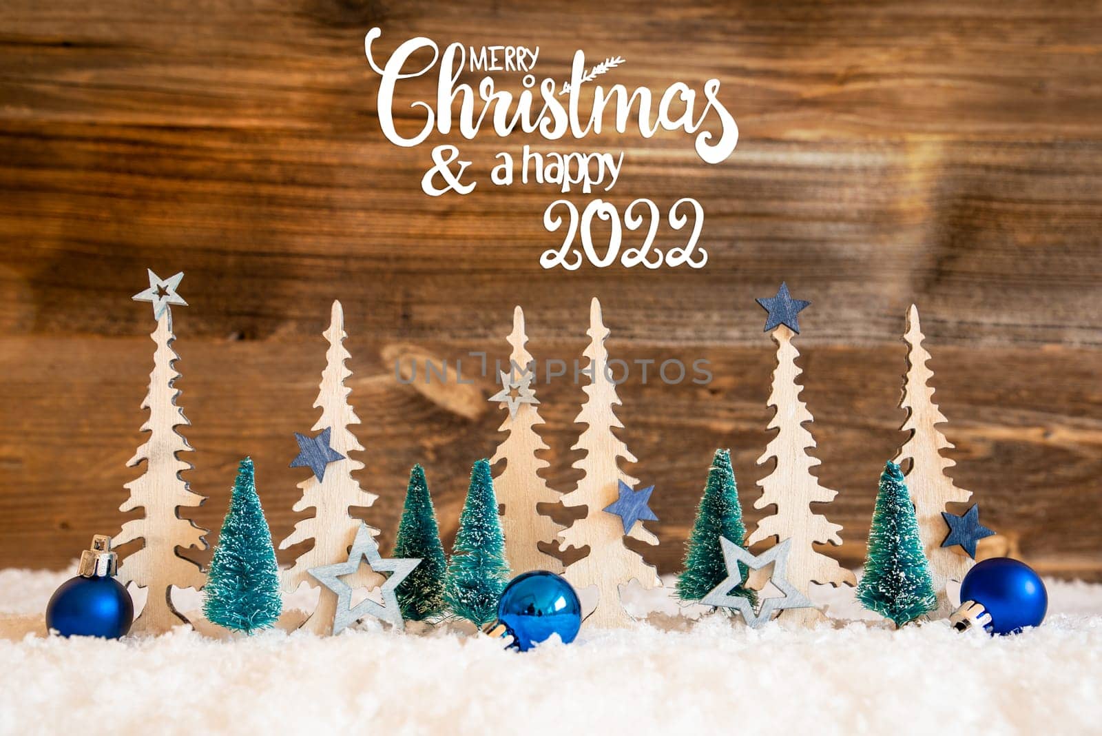 Christmas Trees With English Text Merry Christmas And Happy 2022. Christmas Decoration Like Blue Star Ornament And Balls. Brown Rustic Background With Snow.