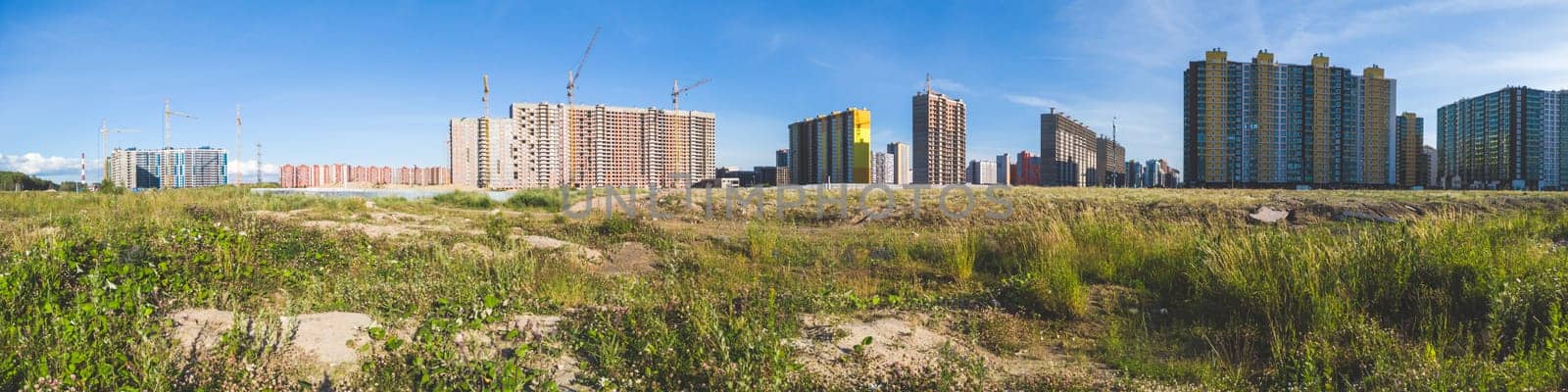 Building construction behind the field. cityscape panorama