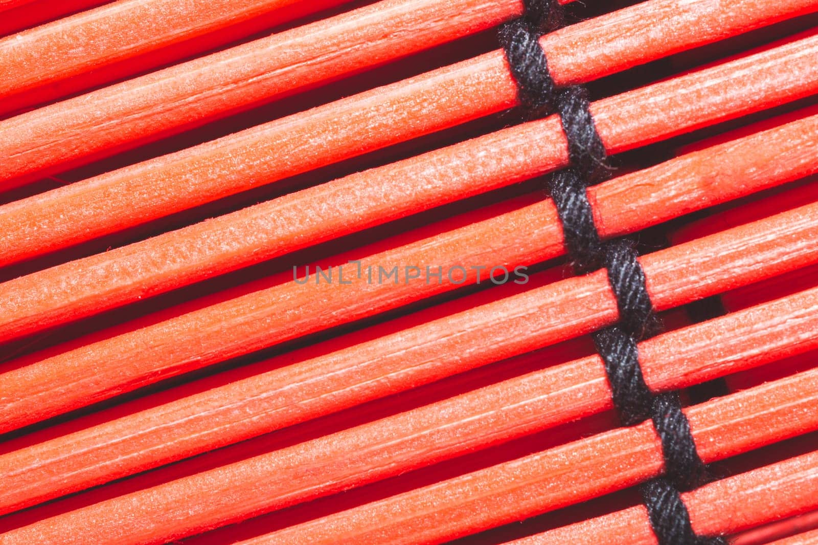 Bamboo mat background close up. wooden backdrop. red wooden sticks bound together