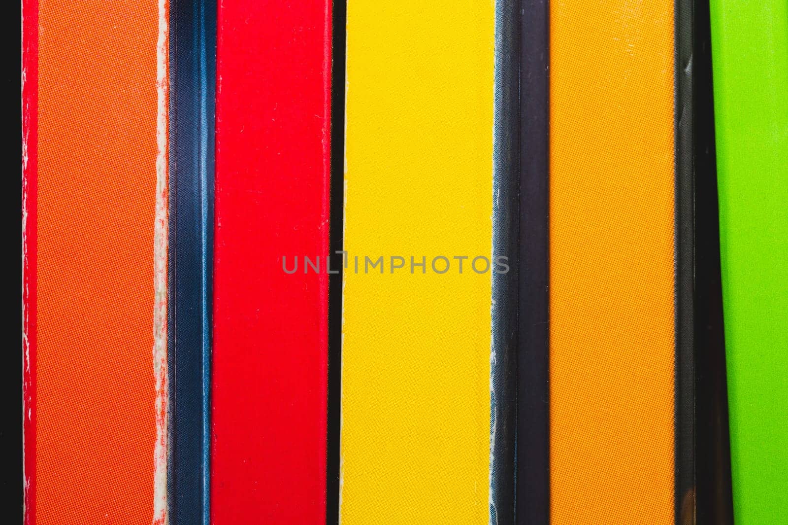 Stack of colorful books. spine of the book close up. abstract background