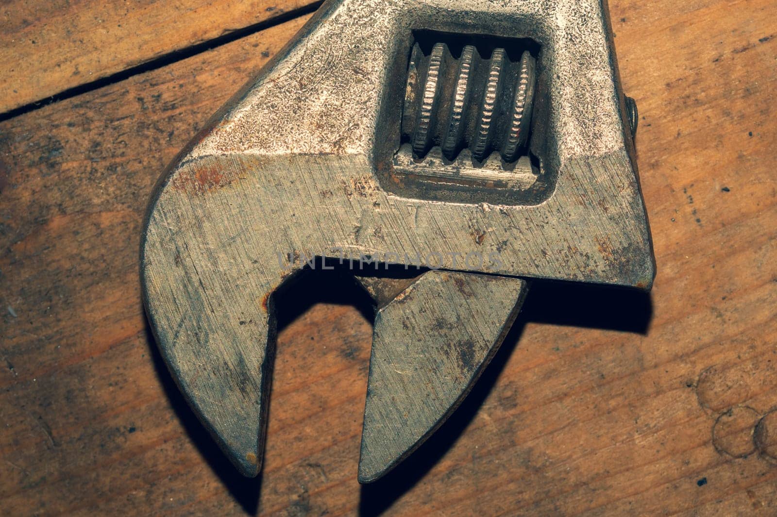 Old adjustable wrench on wood background. working tool. plumbing repairing instrument