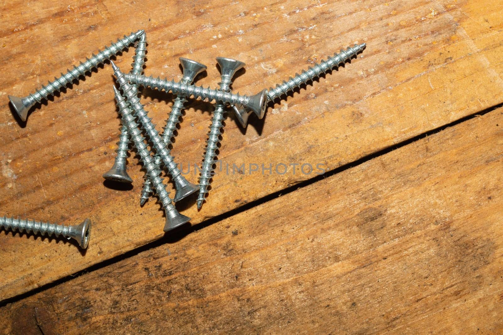 Screws on a wooden background.working tools. copy space