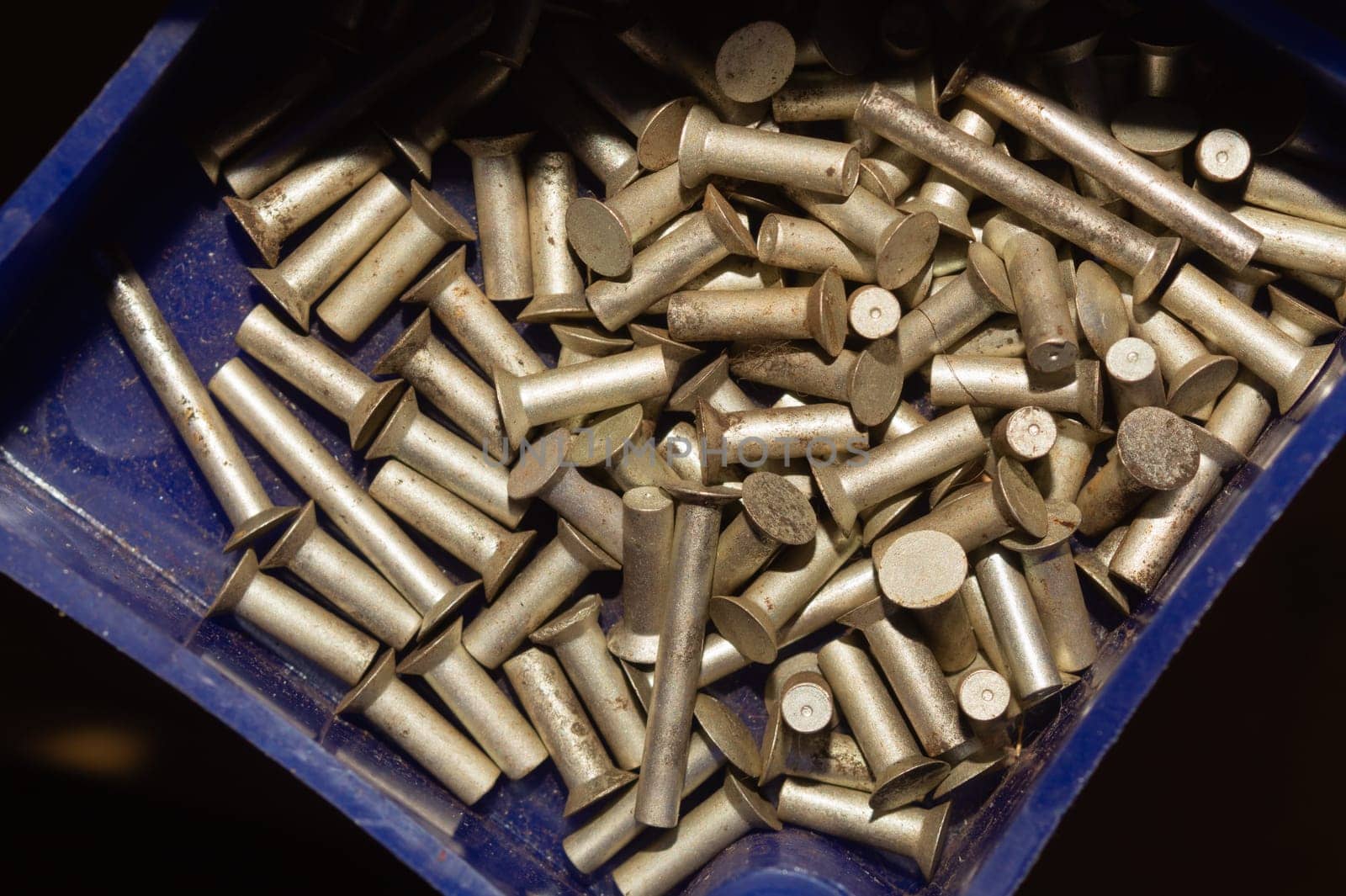 Old screws in a box. a lot of various screws. pile of fasteners in the box close up. carpentry workshop. work tool