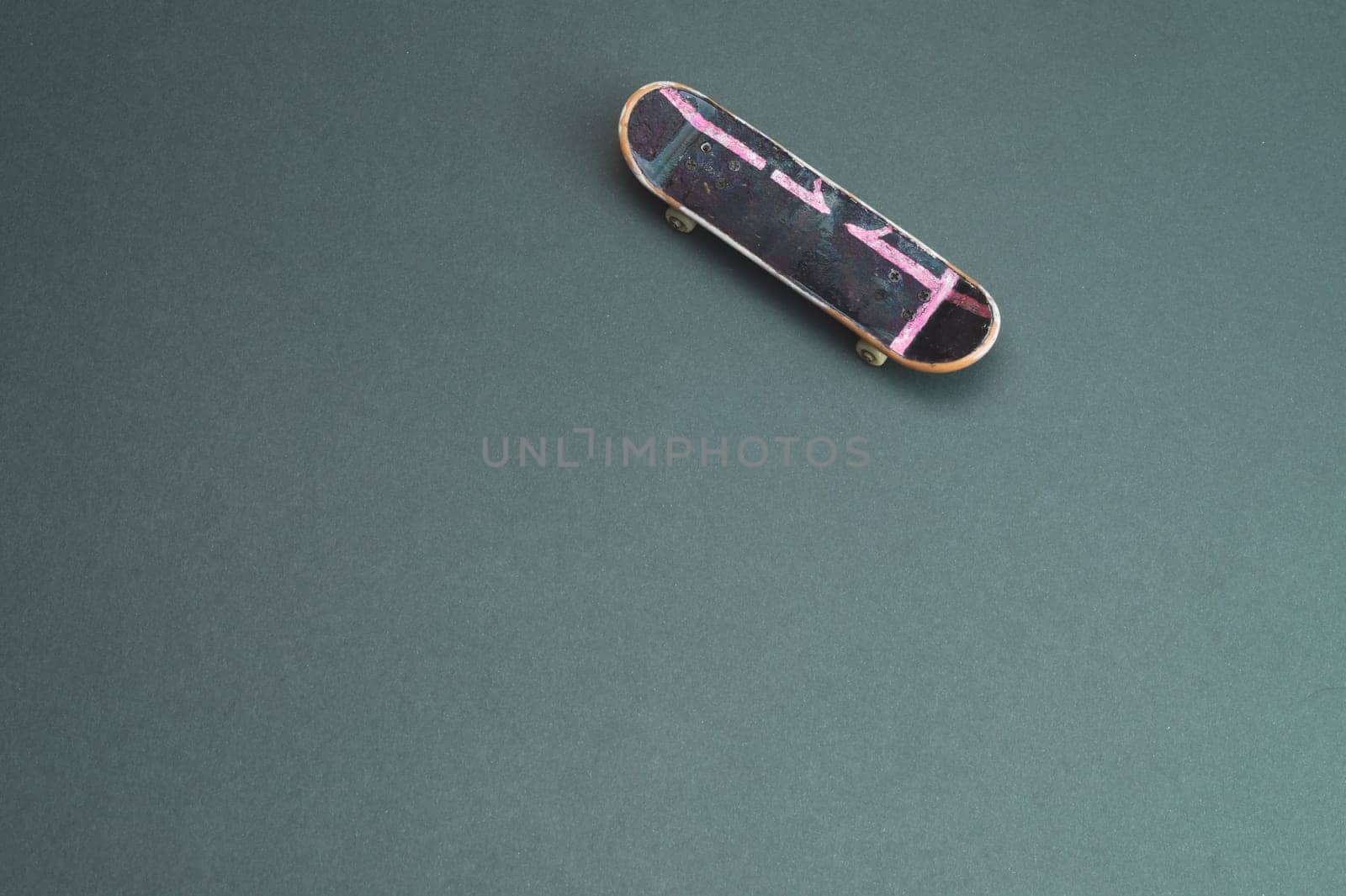 Small skateboard on color background. tiny skate for fingers. fingerboard close up. copy space