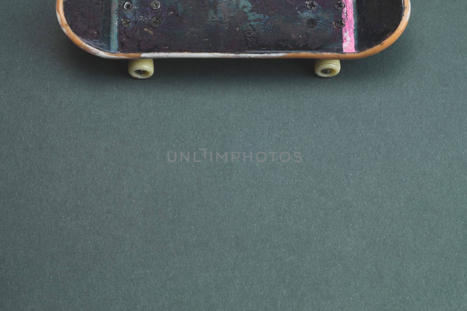 Small skateboard on color background. tiny skate for fingers. fingerboard close up. copy space
