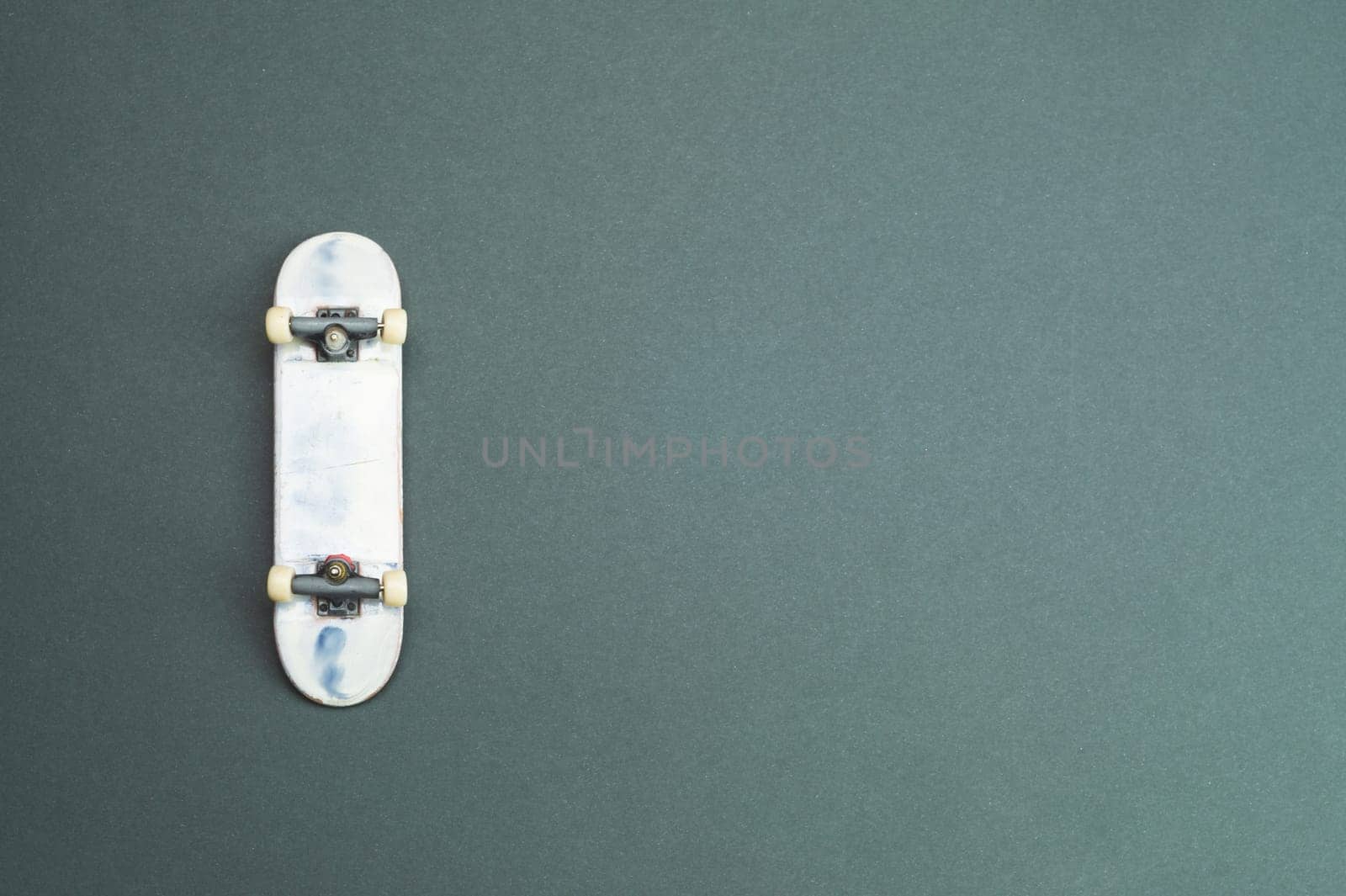 Small skateboard on color background. tiny skate for fingers. fingerboard close up. copy space