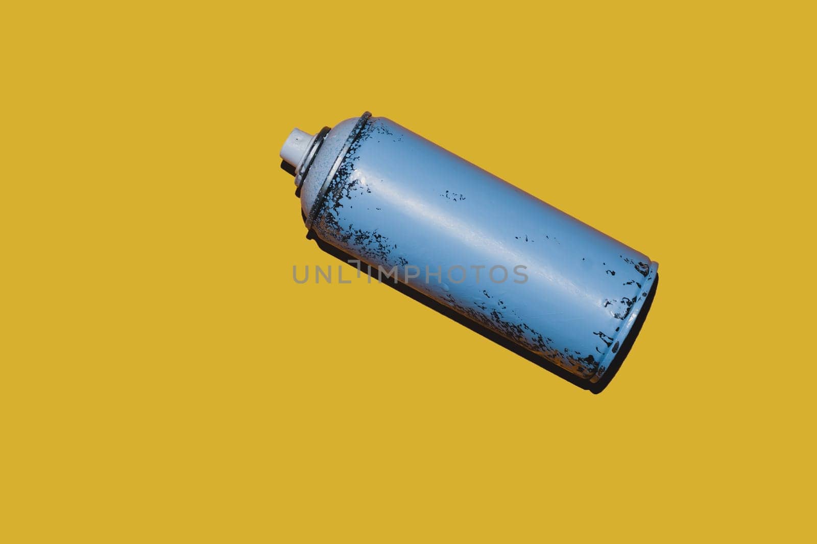 Used can of spray paint isolated on yellow background