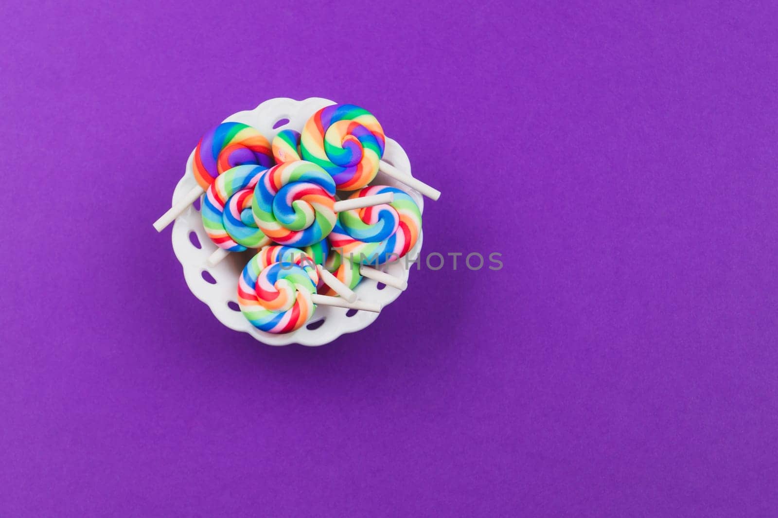 Lollipops close up. colorful candies on a purple background. festive decoration. copy space