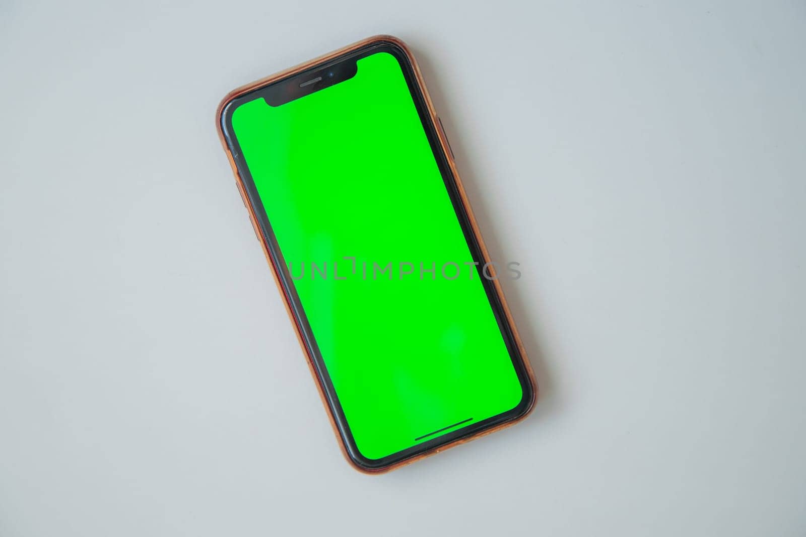 The phone with a green screen is on a white background. High quality photo