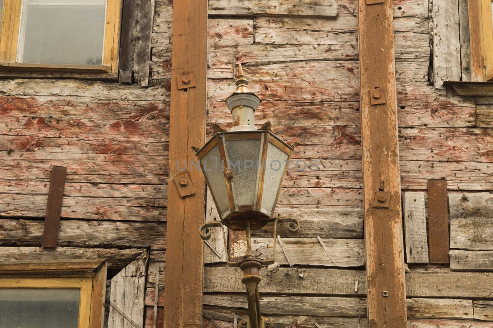 Windows of the old wooden house. wooden plank wall with vintage lamp