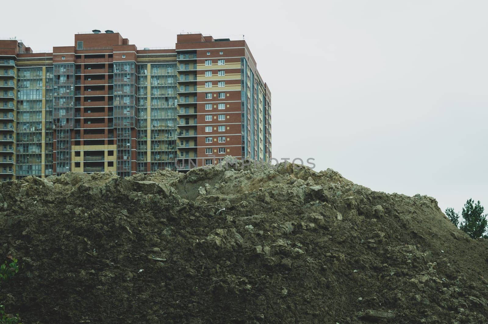 Sand hill with a building on the background. industrial construction