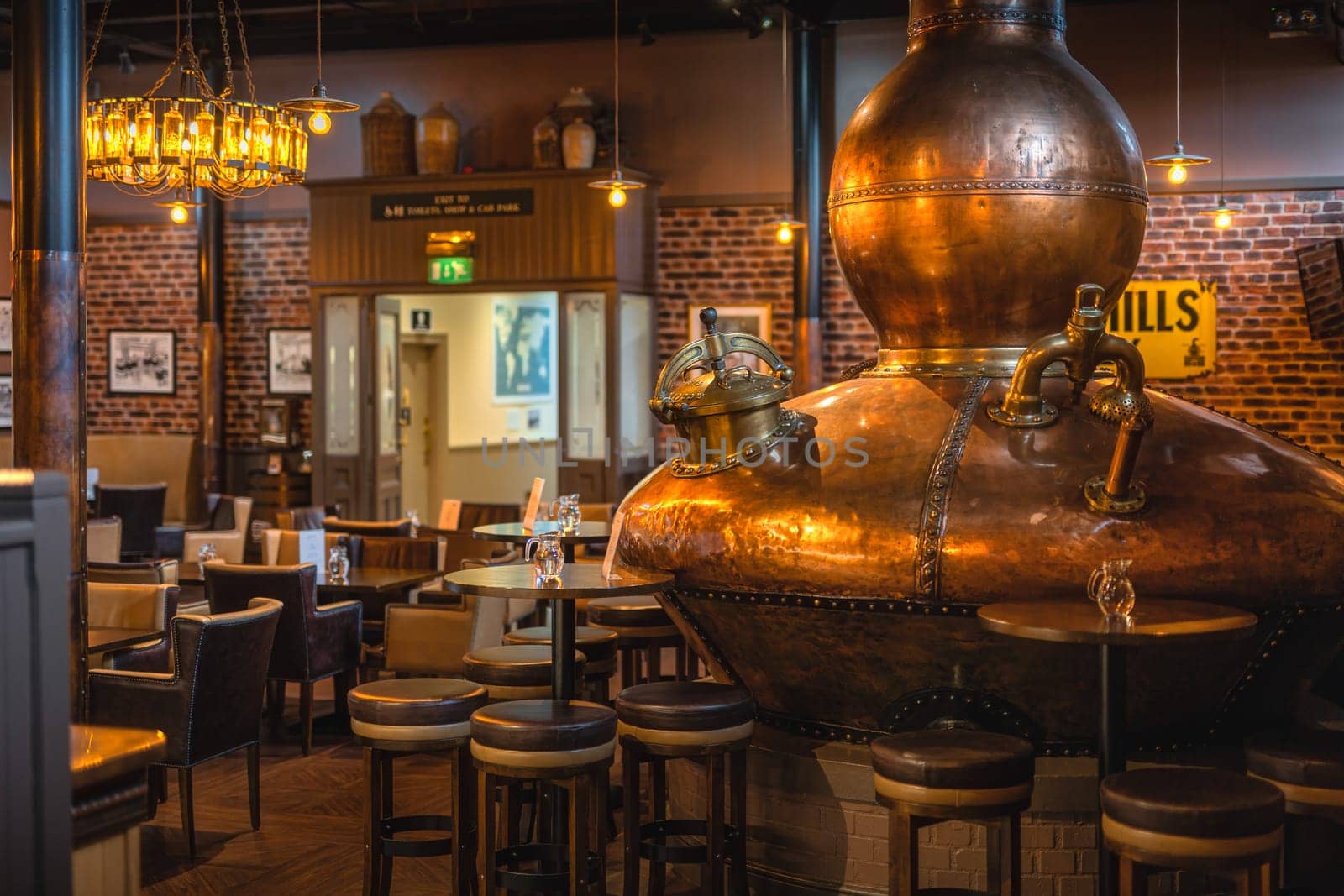 Bushmills, Northern Ireland, Aug 2019 Large, copper fermentation vat in Bushmills whiskey bar as decoration, distillery visitor centre and shop