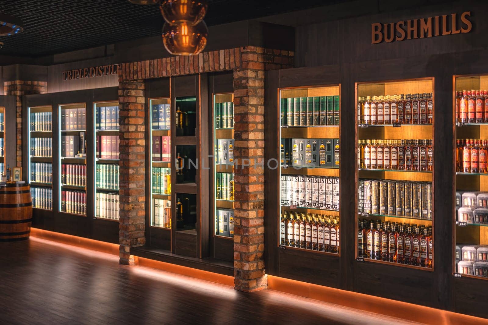 Bushmills, Northern Ireland, Aug 2019 Variety of Bushmills whiskey in a rows on illuminated shelf on a display in distillery visitor centre and shop