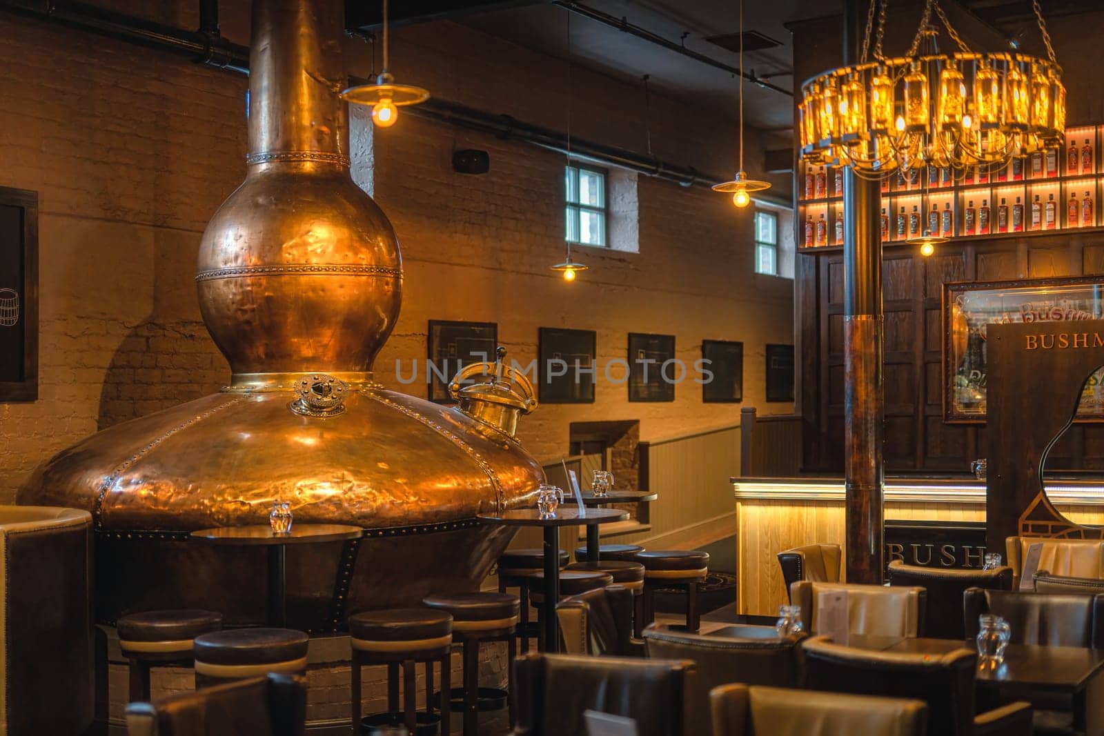 Bushmills, Northern Ireland, Aug 2019 Large, copper fermentation vat in Bushmills whiskey bar as decoration, distillery visitor centre and shop